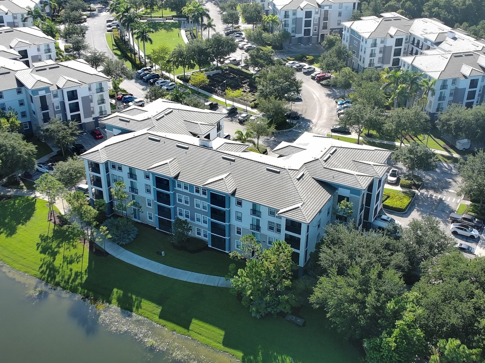 Drone aerial photo of a residential community in Wellington, Florida, showing apartment buildings, landscaping, and a lake